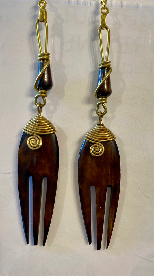 Pair of wooden fork-shaped earrings with gold wire wrapping on a white background