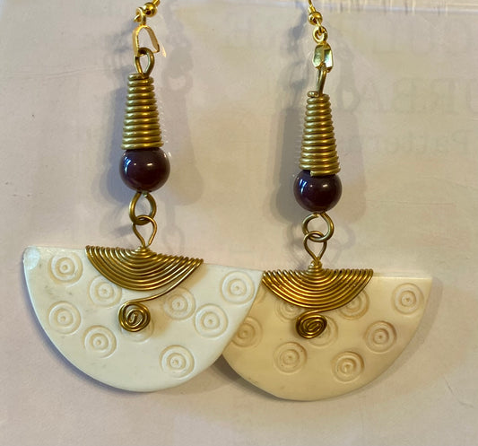 Pair of earrings with gold and brown elements on a white background