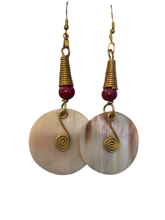 Pair of earrings with spiral designs and red beads on a white background
