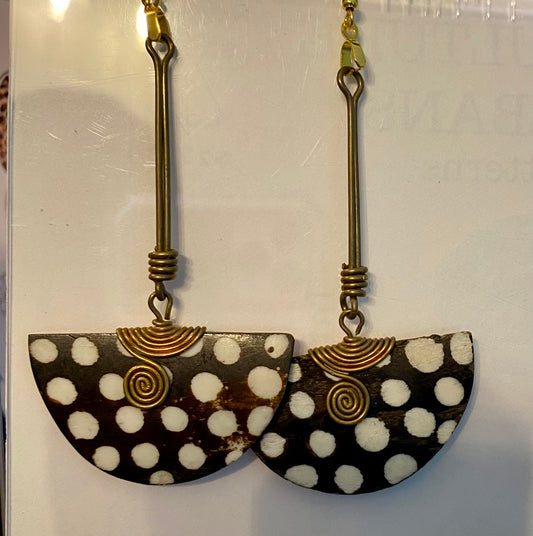 Pair of earrings with black and white polka dot design and gold accents on a light gray background.