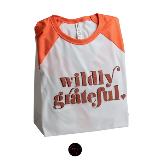 White and orange shirt with 'wildly grateful' text on a white background