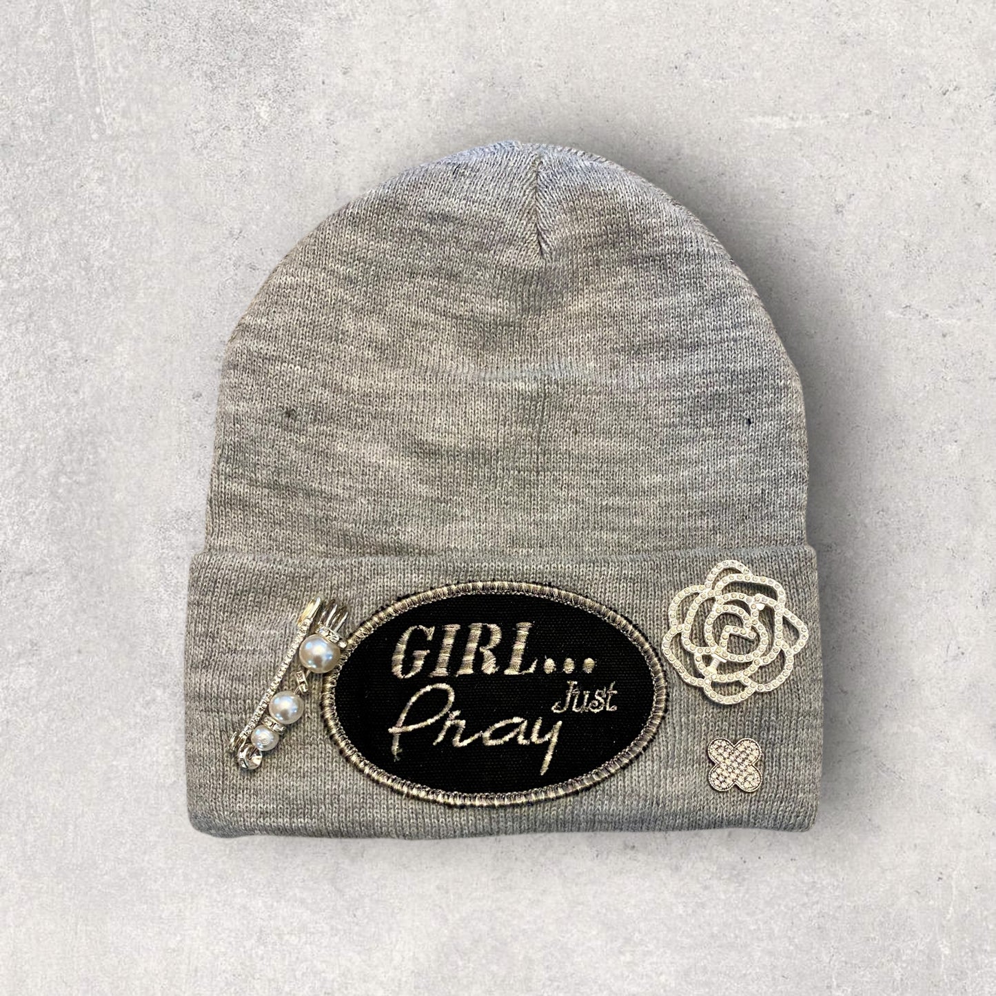 Gray beanie with decorative patches on a light gray background
