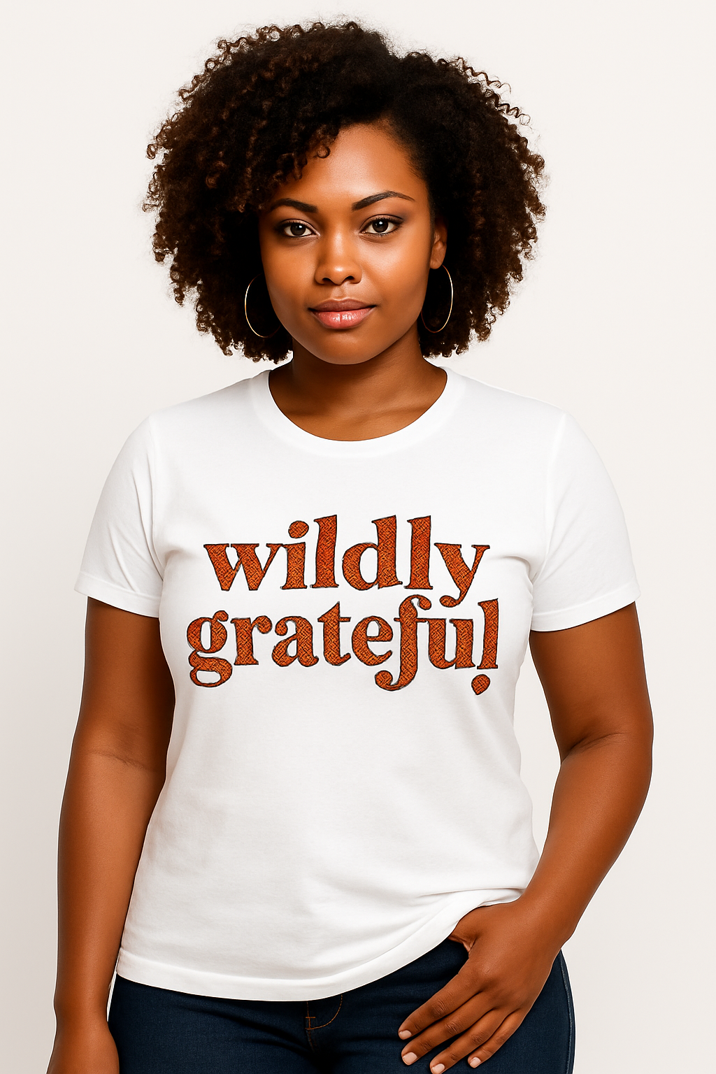 Woman wearing a white t-shirt with 'wildly grateful!' text on a plain background